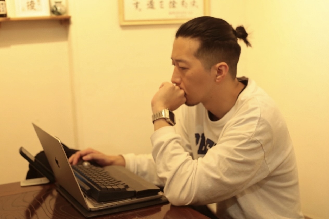 ノートパソコンに向かって作業するつばさ先生